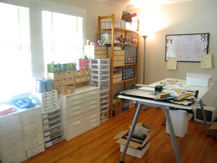 organized craft room with storage, drawers and work table.