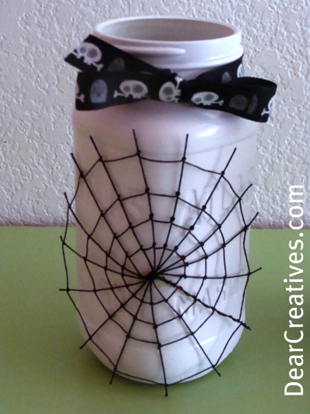 mason jar decorated for Halloween with a spider web and skull ribbon - DIY and Halloween Ideas at DearCreatives.com