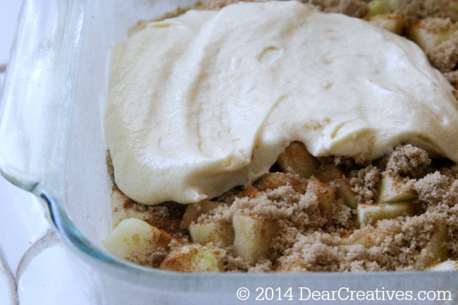 cake batter in a pan with apples and brown sugar_