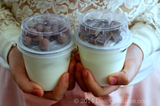 hands holding two types of Hersheys Yoplait Yogurt Cups_