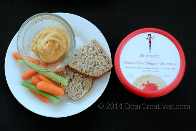 Hummus in a bowl on a plate with veggies and Skinnygirl Roasted Red Pepper Hummus next to skinnygirl hummus