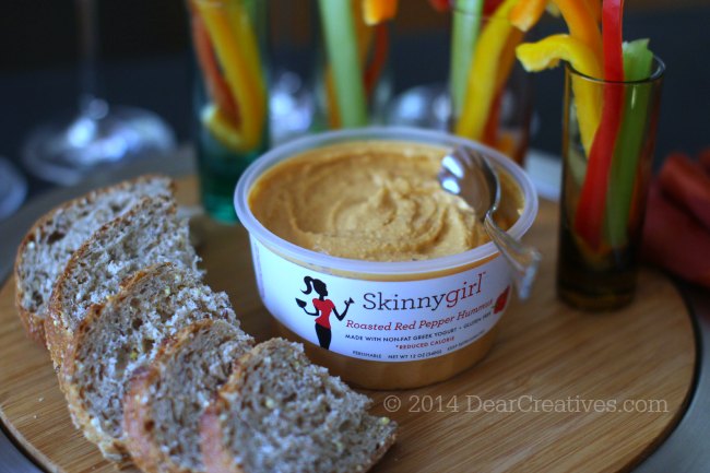 Opened package of skinnygirl roasted red pepper hummus on an appetizer serving tray