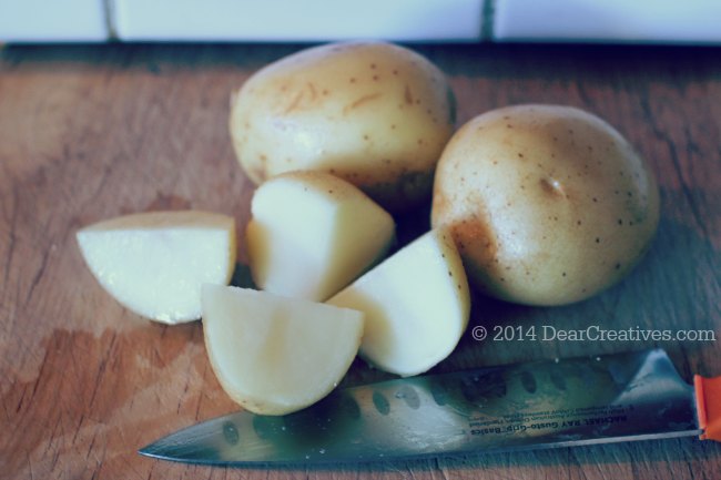 White potatoes quartered and a knife_ white potatoes_