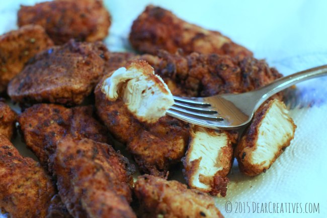 Cooked Chicken Tenders with a piece of one on a fork_