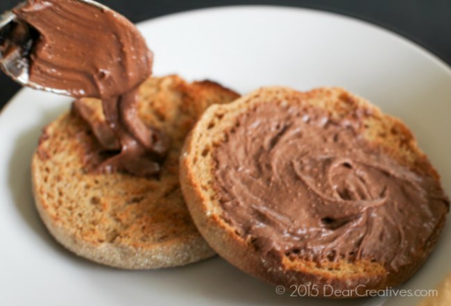 Reese's Chocolate Peanut butter spread on a whole wheat English muffin