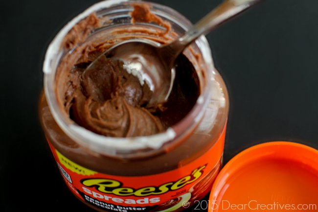 opened jar of Reeses spreads_ peanut butter spread with a spoon in it_