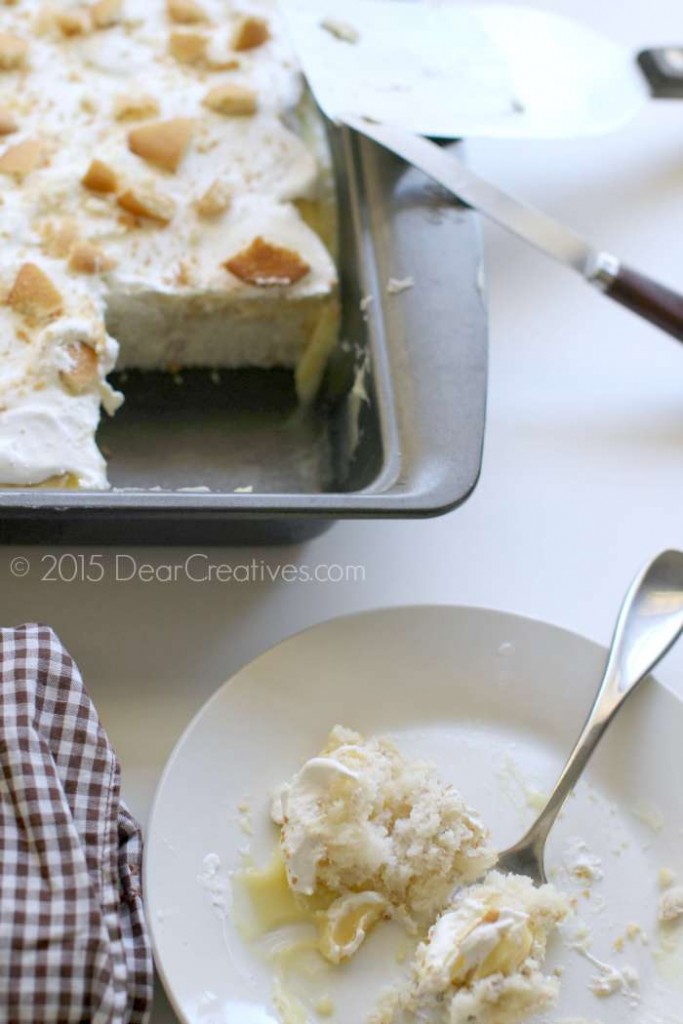 Banana pudding cake after chilling with a slice cut out and a slice of the cake on a plate almost finished.