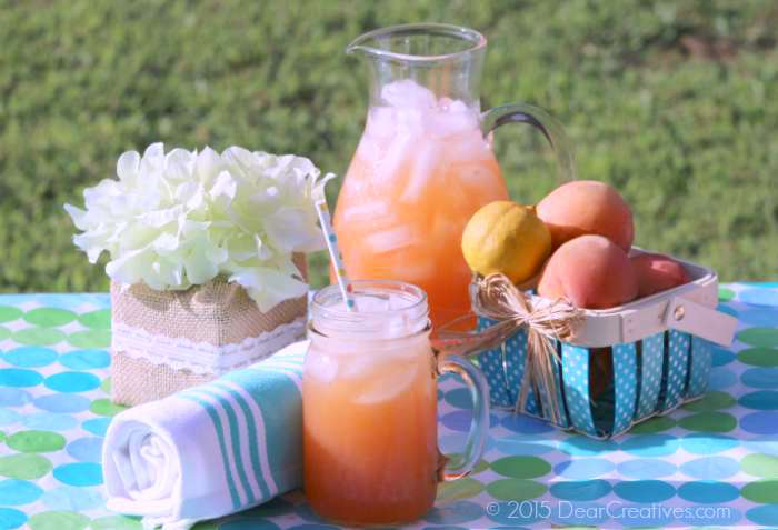 Peach Strawberry Lemonade outside on a picnic table - a homemade lemonade with peaches and strawberries. This is an easy drink recipe to make. DearCreatives.com