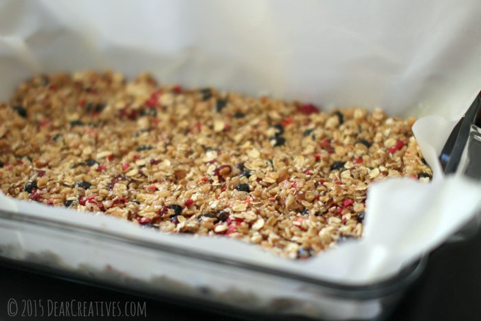 Granola pressed down in a baking dish ready to bake for granola bars