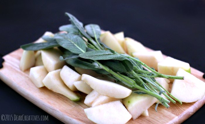 Peeled and sliced pears and sage on a cutting board