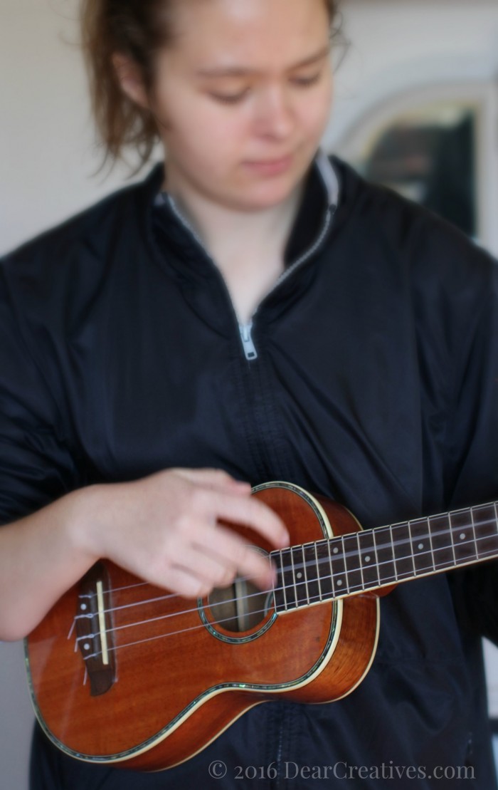 Teen playing a Ukulele