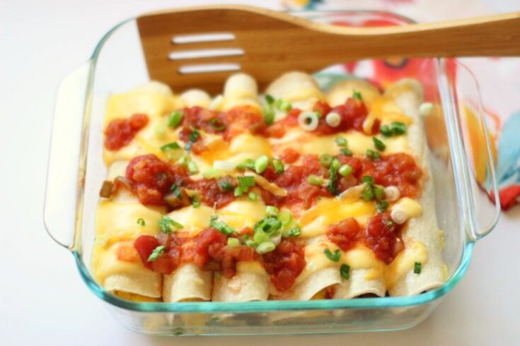 Finished pan of breakfast enchiladas topped with salsa and green onion.