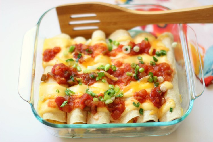 Finished pan of breakfast enchiladas topped with salsa and green onion.