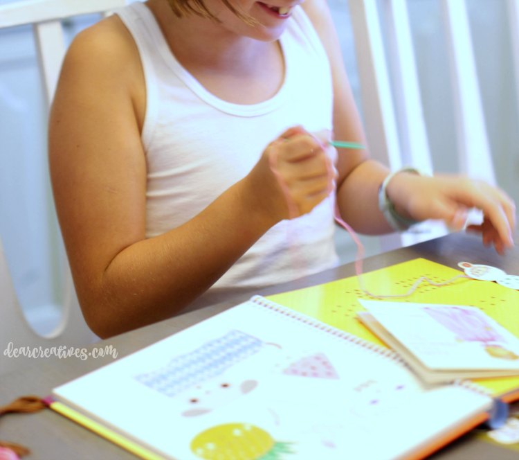kids-crafts-girl-learning-to-stitch-with-stitching-cards-from-a-kids-book
