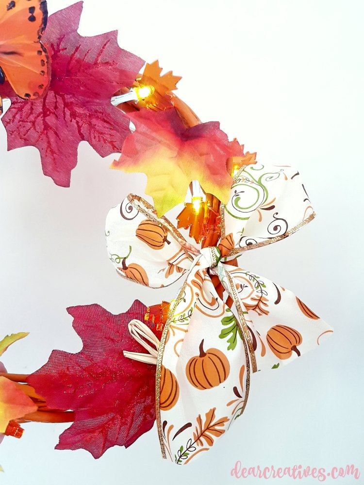 Close up of bow on grapevine wreath made for fall. See diy at DearCreatives.com