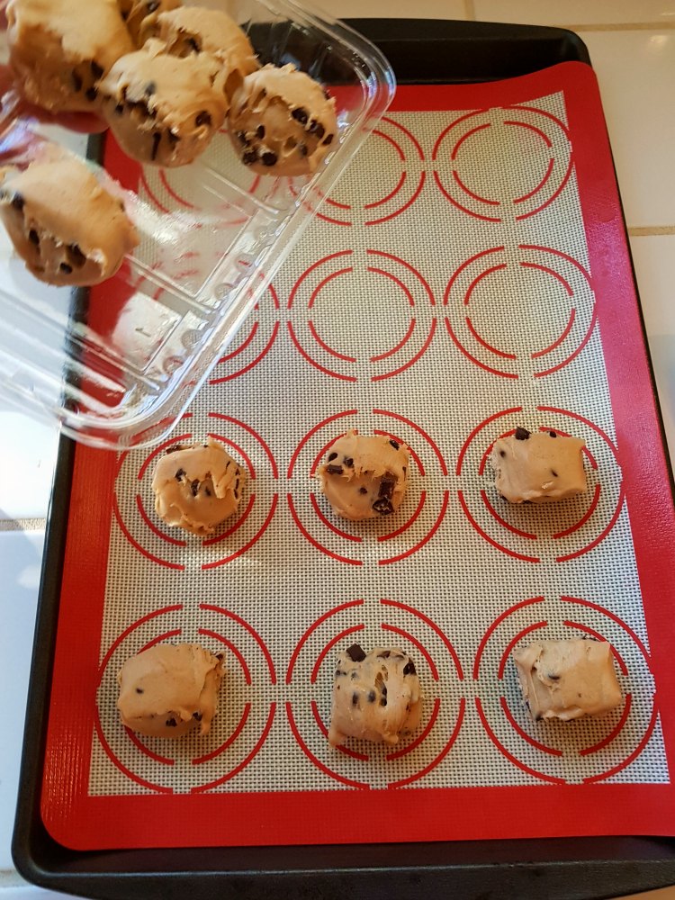 chocolate chip cookie dough being put onto a cookie sheet for a Halloween cookies recipe