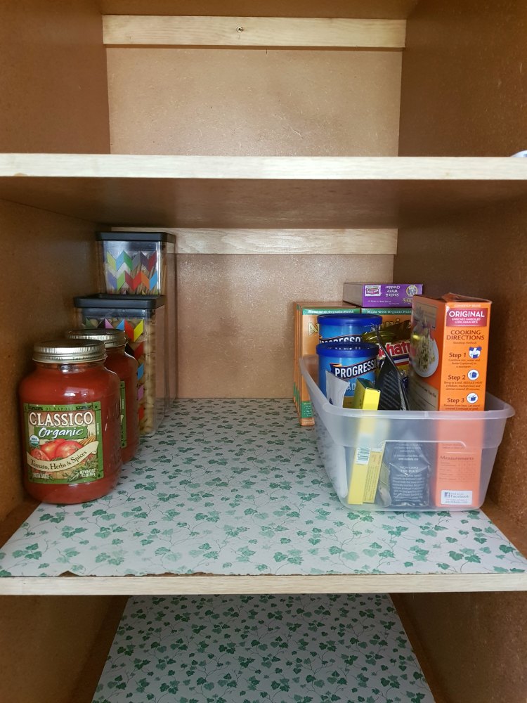 Restocking the kitchen pantry after cleaning the shelving DearCreatives.com