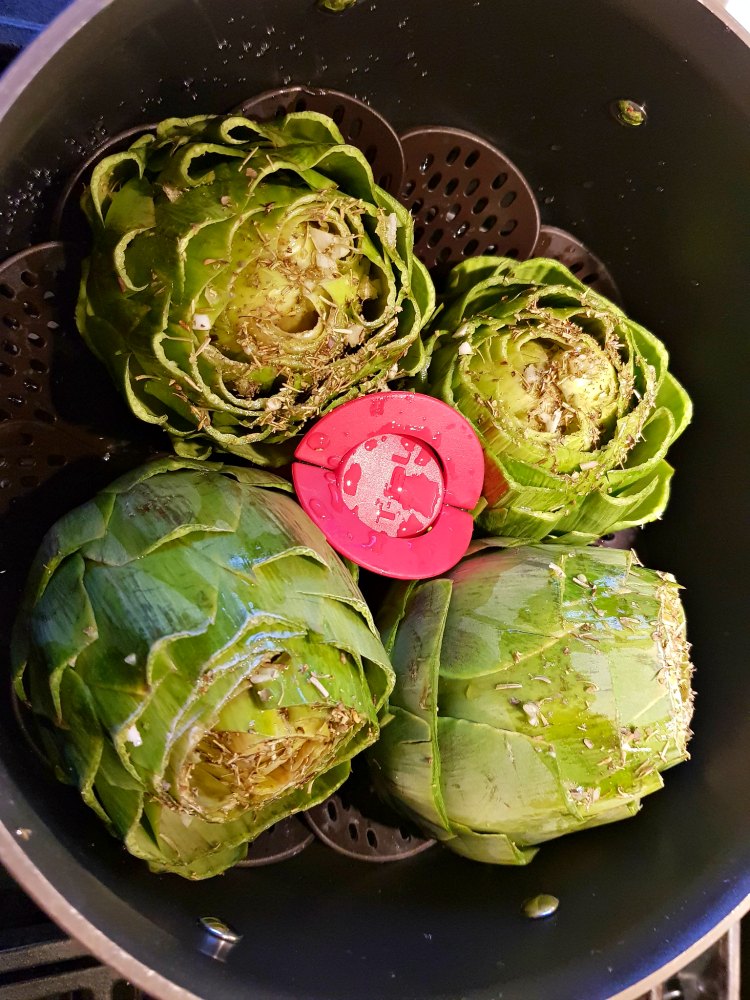 artichokes in a steamer basket in a pot ready to be cooked. © DearCreatives.com