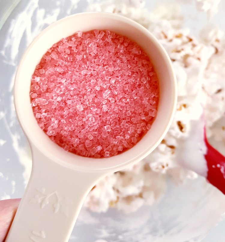 Next add candy sprinkles to your popcorn treat mixture. See full recipe at DearCreatives.com