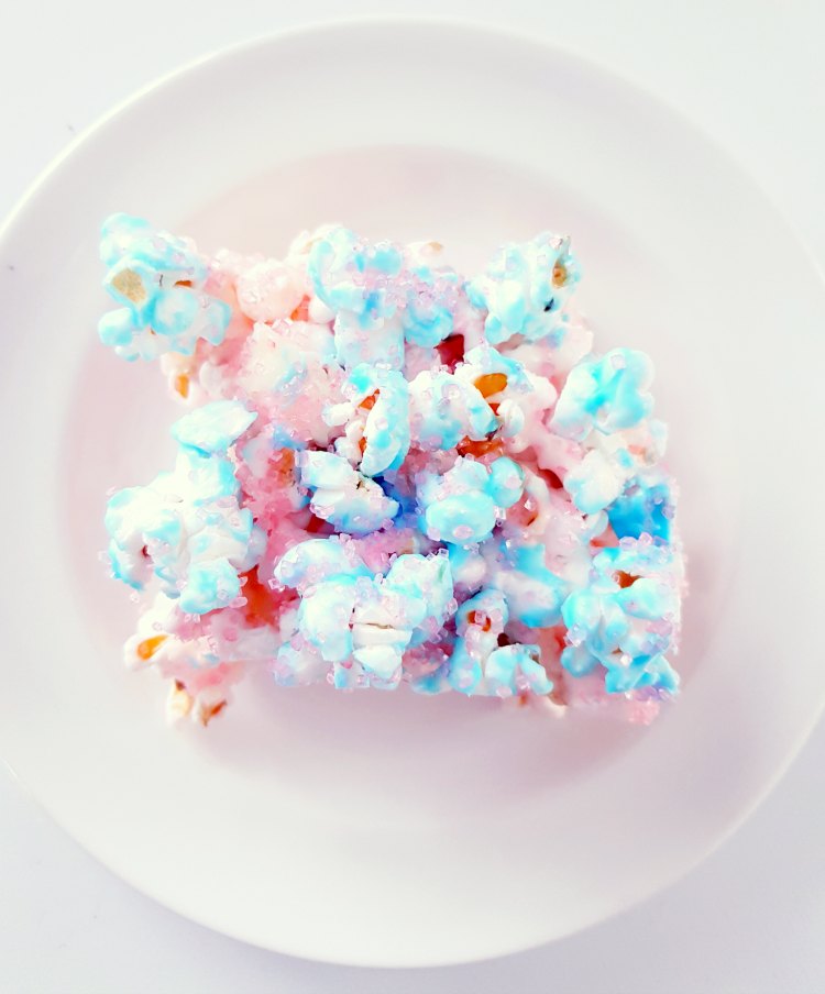 Pink blue popcorn bars on a plate These are a popcorn treat that tastes like cotton candy. DearCreatives.com