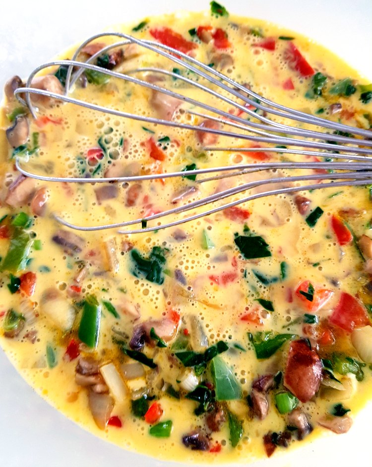 Mixing the egg, cream and vegetables for a mushroom quiche © DearCreatives.com