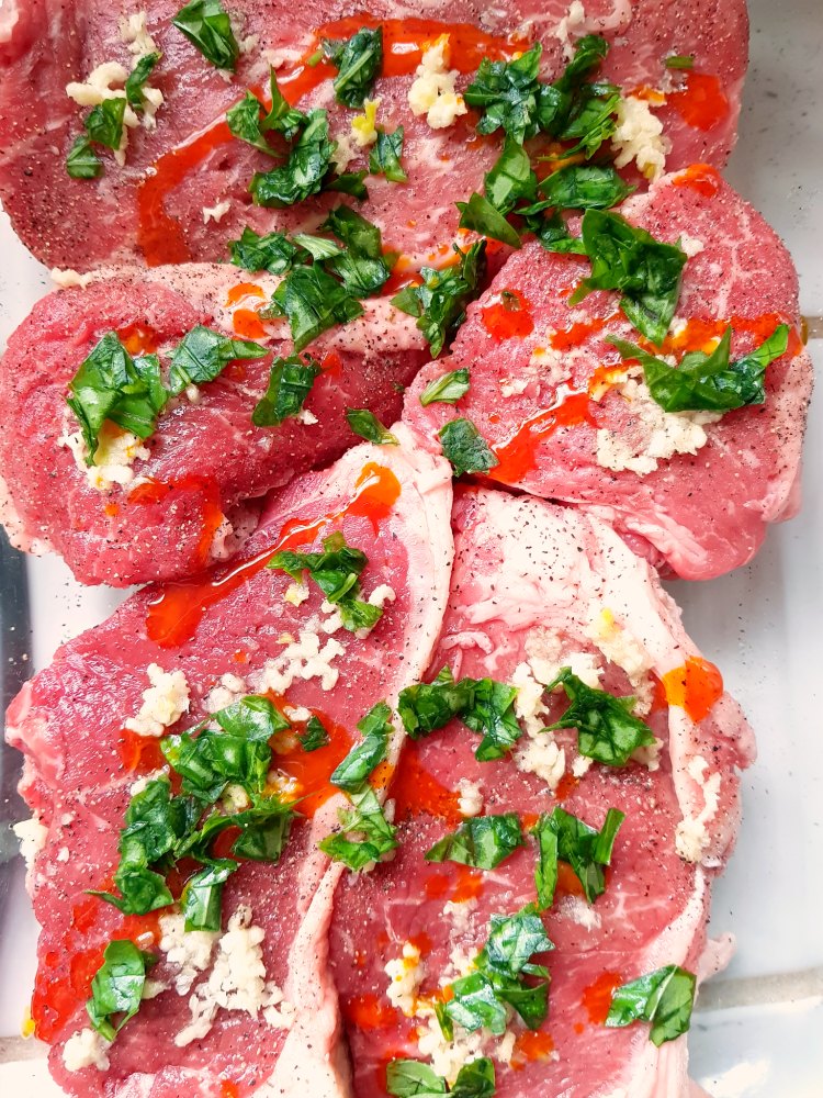 steak with crushed garlic and basil