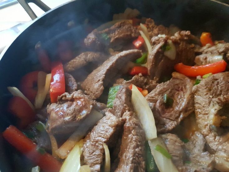 Beef Stir Fry beef, red and green bell peppers, onion, broccoli florets, carrots, in a skillet cooking: recipe at DearCreatives.com