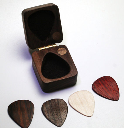 Four wooden guitar picks, and storage case 