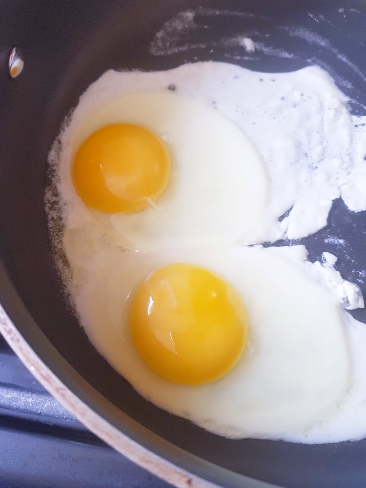 Eggs cooking in a non stick skillet for Southwest Quinoa and Eggs Breakfast Bowl DearCreatives.com