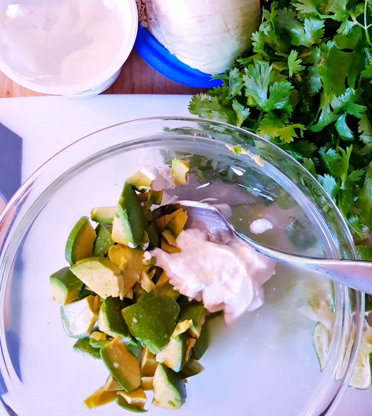 Greek Yogurt, white onion, cilantro, lime. Avocado and yogurt in a bowl with lime for an avocado recipe DearCreatives.com