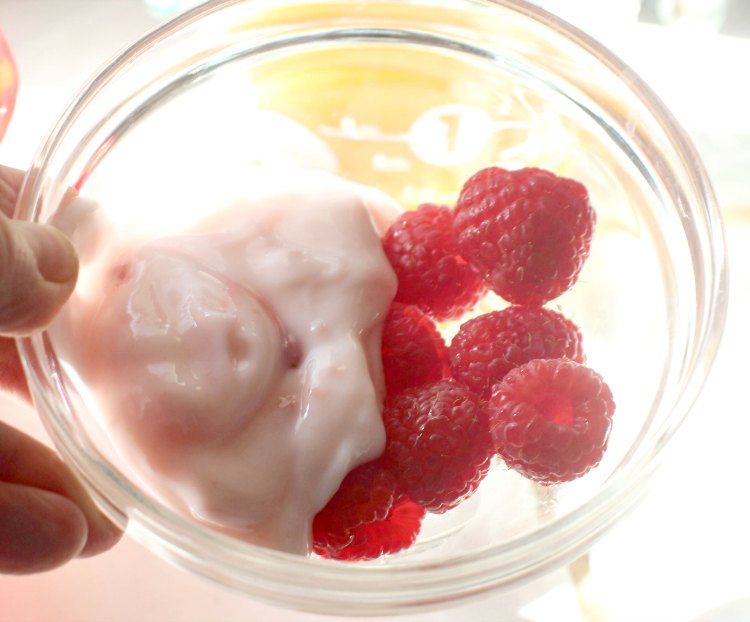 3 tablespoons of strawberry yogurt and a handful of raspberries in a bowl for a smoothie. Smoothie recipe at DearCreatives.com