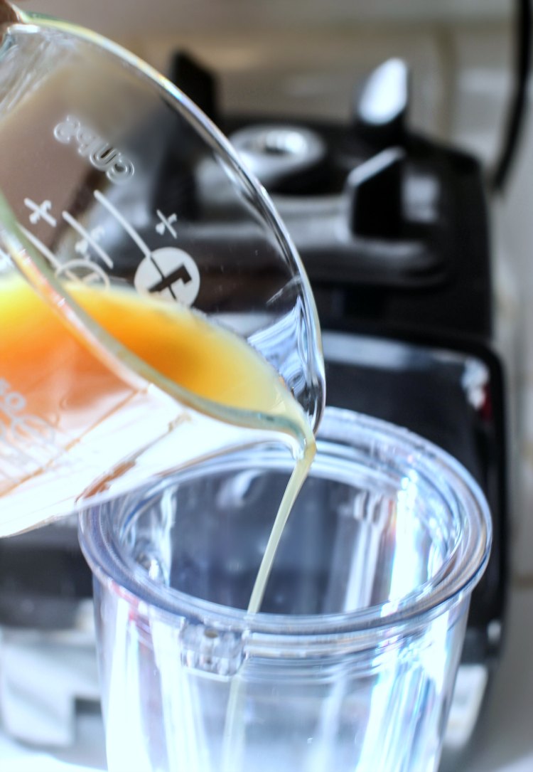 pouring organic apple juice to a to go cup to blend with the Vitamix Personal Cup Adapter DearCreatives.com