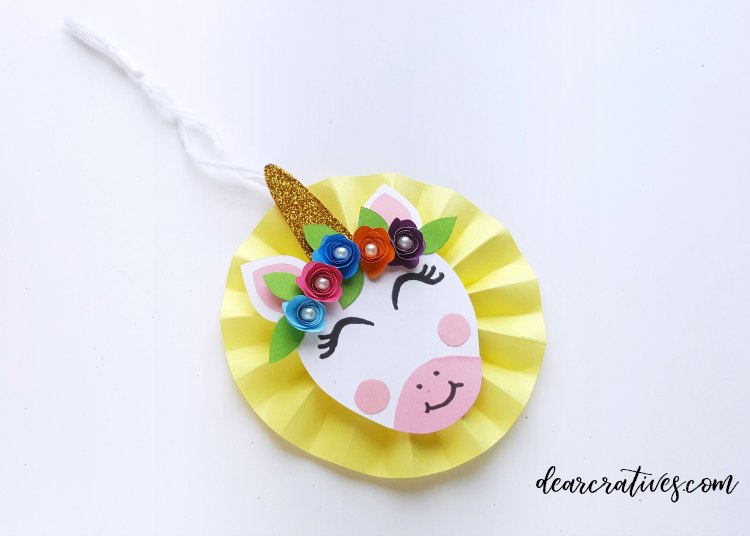 #unicornornamentdiy The last step is securing the unicorn face to the paper circle with string. Now you can make more in other colors. step (12) of the unicorn ornament. DIY at dearcreatives.com #crafts #unicorns