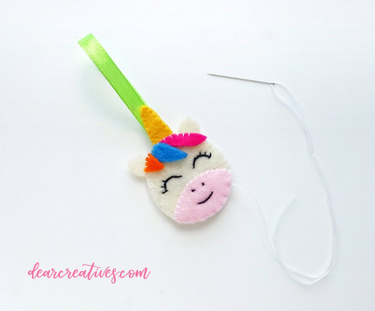 Sewing the unicorns hair on the felt face. See the entire felt craft diy at DearCreatives.com