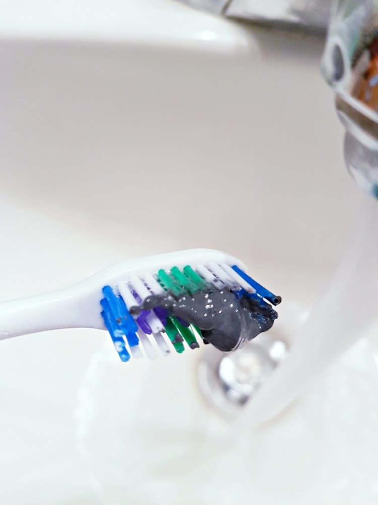 Tips for mouth health and using natural toothpaste. Toothpaste on a Toothbrush ready to brush teeth with natural toothpaste. DearCreatives.com