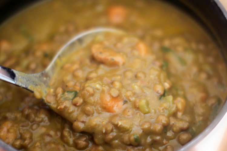 scooping up a ladle full of lentil soup from the soup pot. DearCreatives.com #lentilsoup #souprecipe