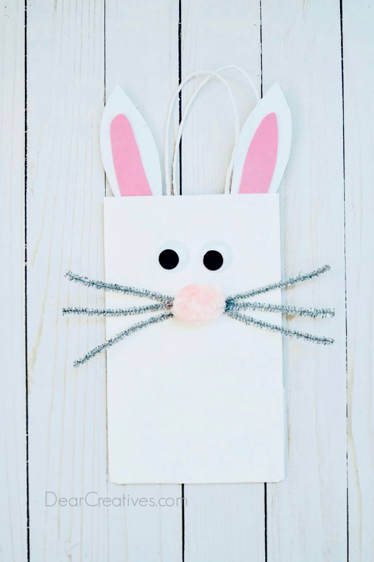 decorated bunny paper bag laying on a flat surface. Instructions with images at DearCreatives.com #crafts #bunnybag #bunnypaperbag #dearcreatives