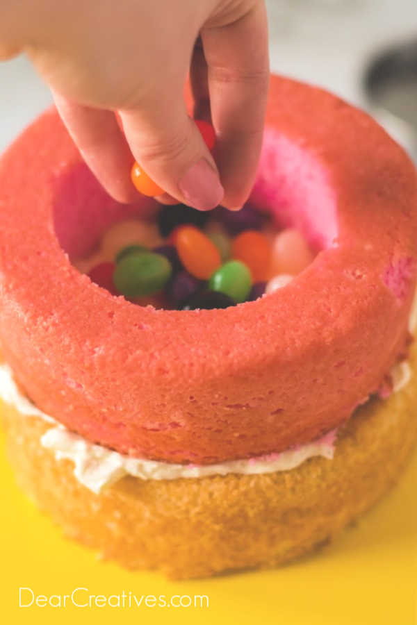 Add your jelly beans or other candies to the center of the cake. It can be all one color for gender reveal cakes, or any combination of colors. Instructions at DearCreatives.com