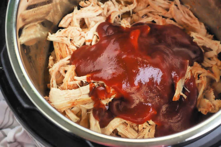 Chicken in the instant pot with BBQ sauce added to the top for pulled BBQ Chicken Sandwiches - DearCreatives.com
