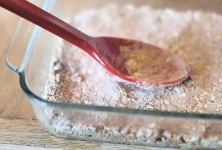 Pressing the crust mixture down in the baking dish for Strawberry Oatmeal Bars DearCreatives.com