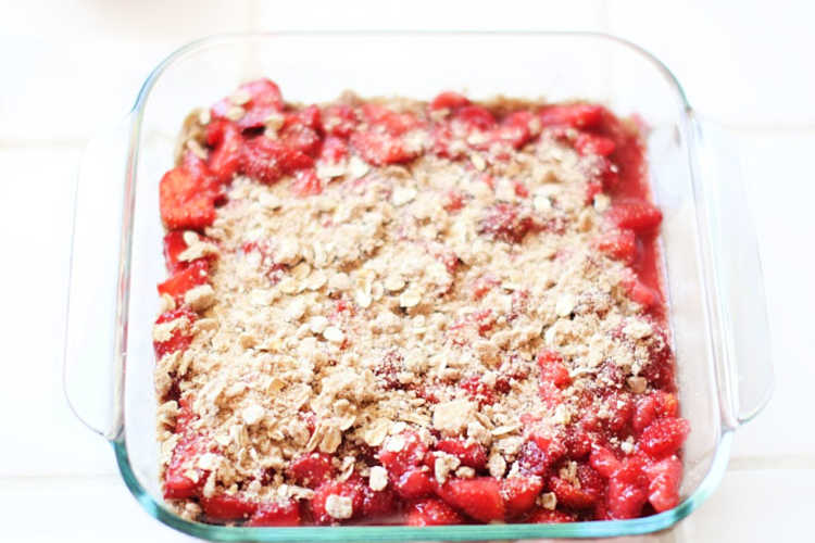 Spreading crumb topping on the strawberries for a dessert strawberry recipe. DearCreatives.com