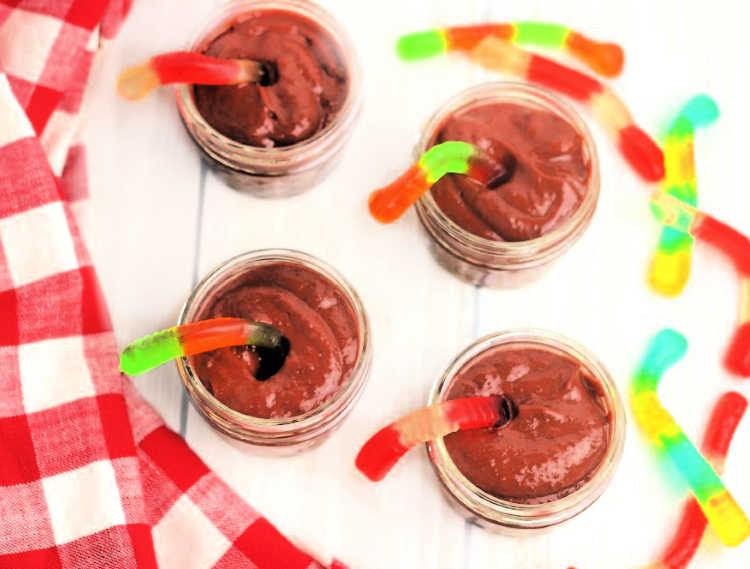 adding the gummy worms to the mini dessert cups recipe. Grab DIY, treat recipe, diy and printable at DearCreatives.com