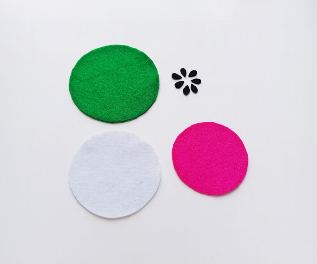 step (1) how to make felt fruit coasters cutting out the different colored circles and watermelon seeds