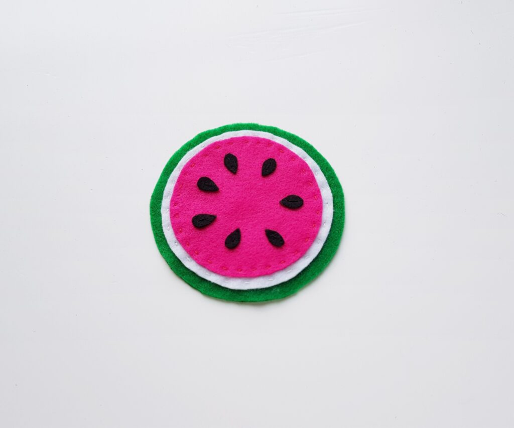 step (4) how to make felt fruit coasters adding the green felt circle base layer to make the coaster look like a watermelon slice