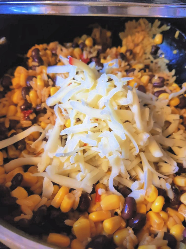 Mexican Rice, black beans, corn, shredded jalapeno jack cheese...mixture in a skillet for making stuffed peppers. DearCreatives.com