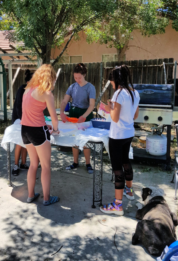 Teens outdoors having a tie-dye party. See how easy it is to have your own party, grab tie-dye techniques and how to's at DearCreatives.com