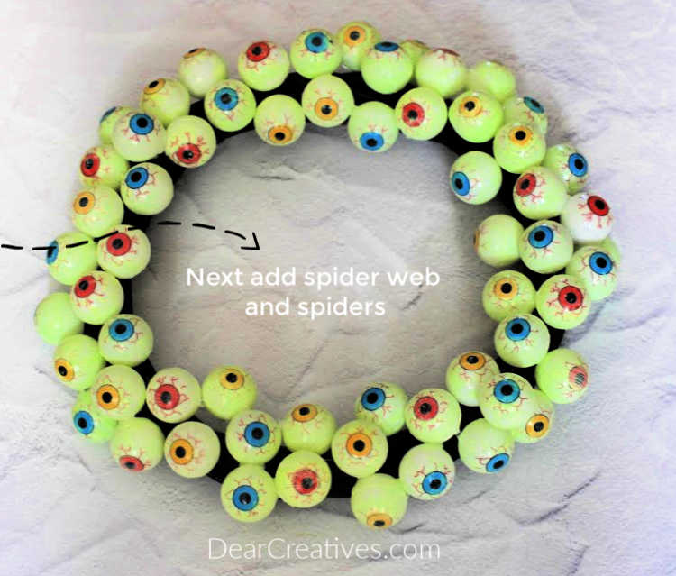 Eyeball Wreath - A wreath with eyeballs and spider web and spiders behind it to hang up for Halloween or spooky, fun parties. © DearCreatives.com