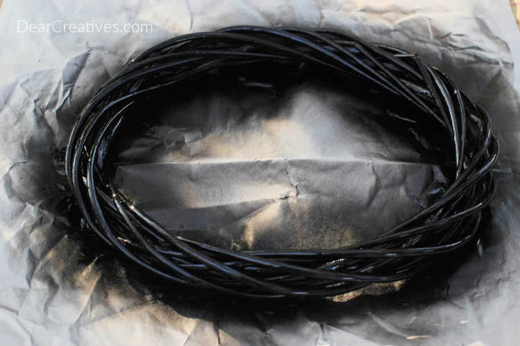 Wreath painted black for the base of the Eyeball Wreath DIY for Halloween Instructions with step by step at © DearCreatives.com