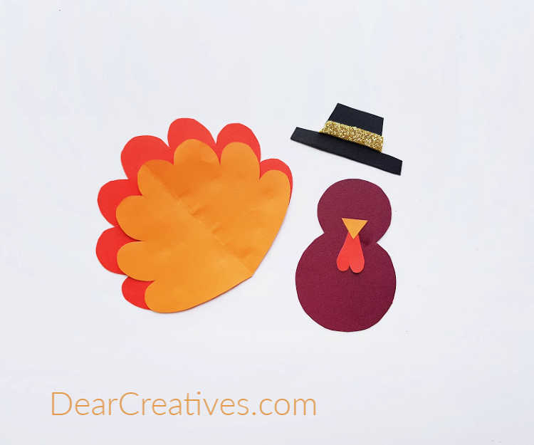 step (2) Beginning to assemble the turkey craft from the cut paper from the turkey template. Find this toilet paper roll turkey craft at DearCreatives.com