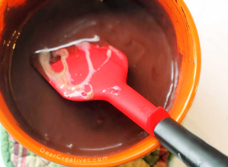 stirring melted chocolate and sweetened condensed milk for a no bake pie in a chocolate graham cracker crust. © DearCreatives.com